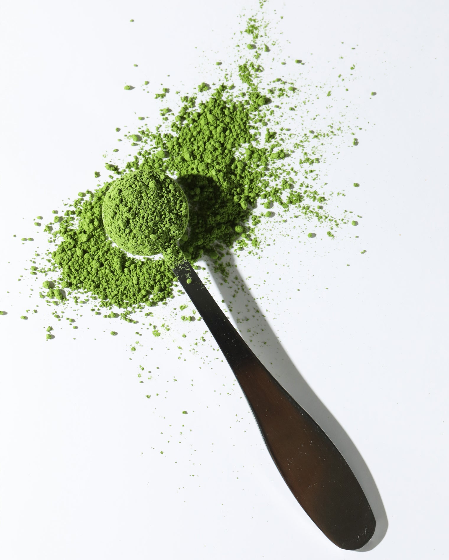 Matcha measuring spoon filled with a bright green matcha powder